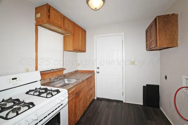 a kitchen with stainless steel appliances granite countertop a stove and a wooden floor