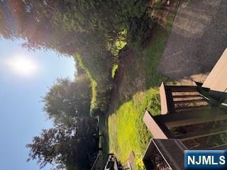 181 Long Hill Road, Unit N5 Little Falls, NJ 07424 - Photo 2 of 3 a view of a backyard with lawn chairs under an umbrella