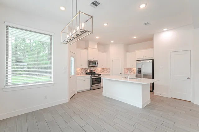 a kitchen with white cabinets and sink