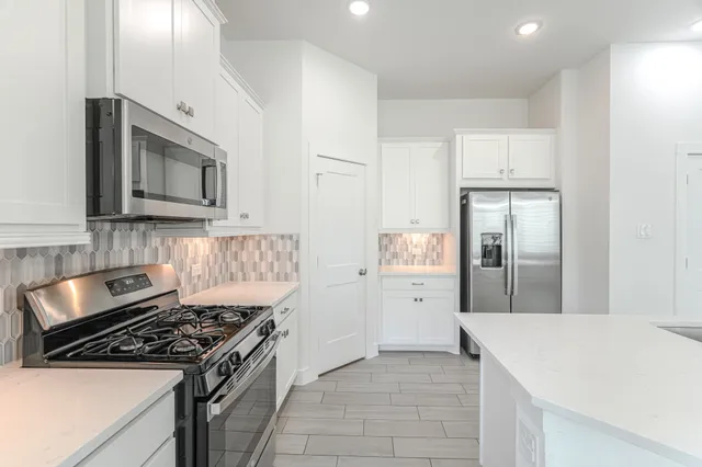 a kitchen with stainless steel appliances granite countertop a stove and a refrigerator