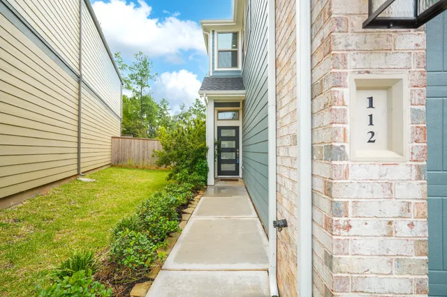 a view of a pathway of house with flower plants