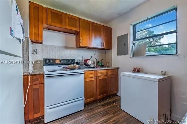 26420 Southwest 138th Court Homestead, FL 33032 - Photo 5 of 5 a kitchen with stainless steel appliances granite countertop wooden cabinets a stove a sink and a microwave