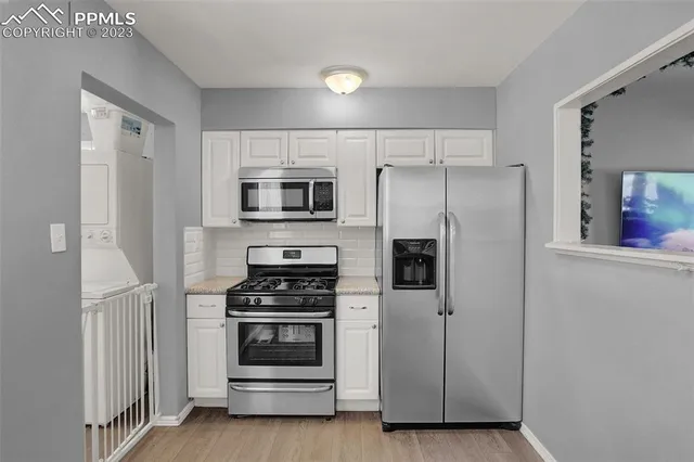 a kitchen with white cabinets and stainless steel appliances