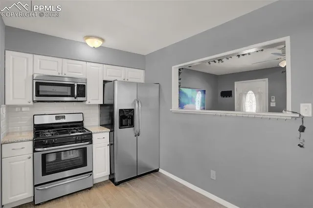 a kitchen with stainless steel appliances a stove microwave and sink