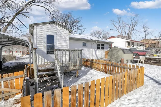 a view of a house with a wooden fence