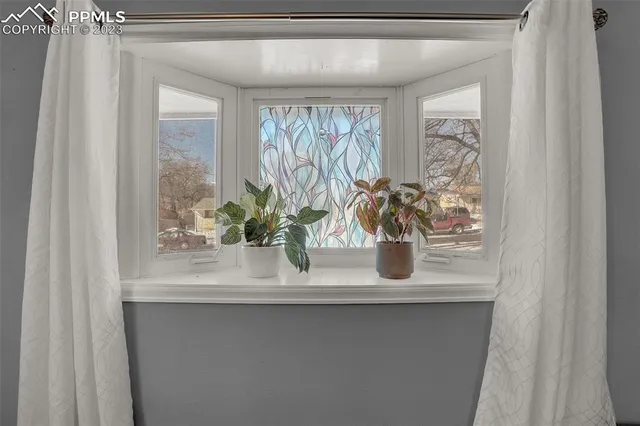 a close view of dining table with a potted plant on a shelf