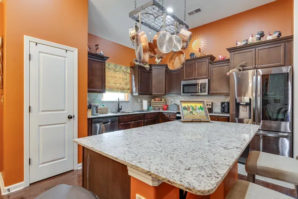 a kitchen with stainless steel appliances granite countertop a sink stove and refrigerator