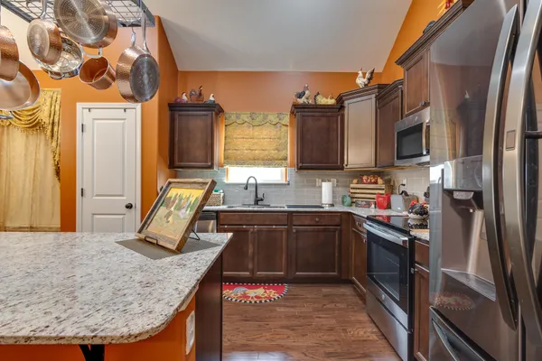 a kitchen with a table chairs sink and wooden floor