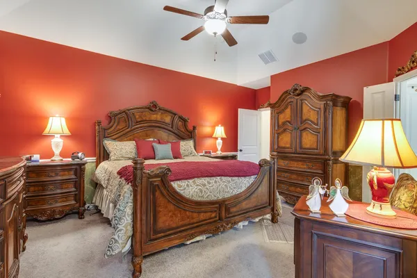 a bedroom with a bed and dresser with mirror