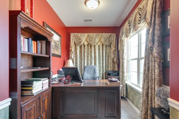 a bedroom with a bed a dresser and window