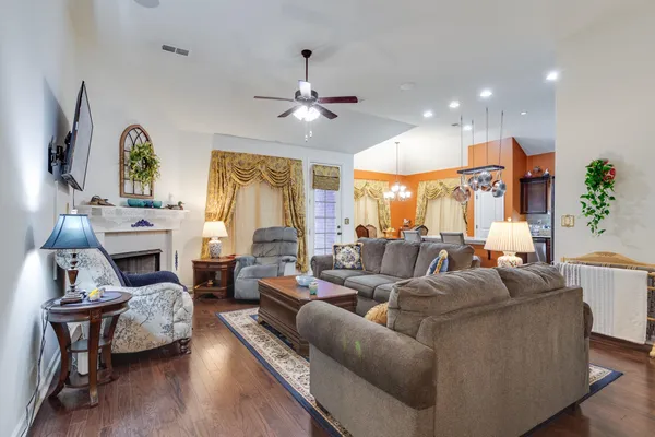a living room with fireplace furniture and a large window