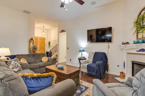 a living room with furniture a flat screen tv and a fireplace