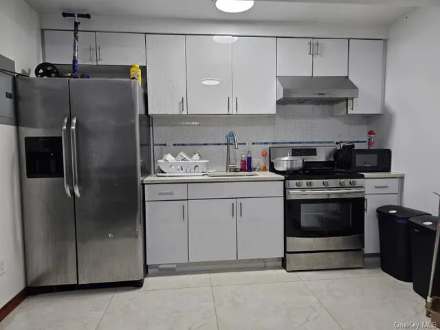 a kitchen with stainless steel appliances granite countertop a refrigerator and a stove