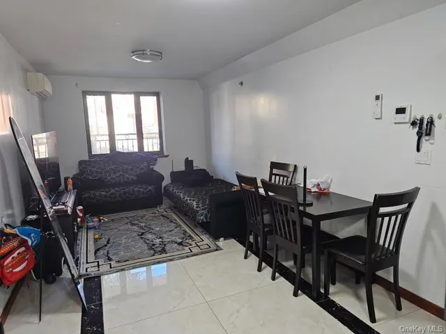a living room with furniture a flat screen tv and a window