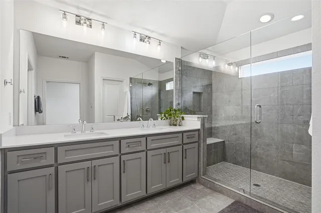 a bathroom with a shower sink and mirror