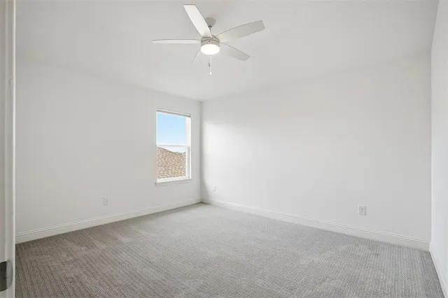 an empty room with a window and a ceiling fan