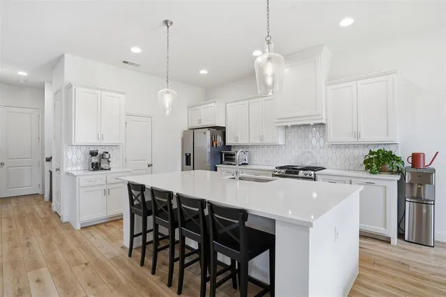 a kitchen with kitchen island granite countertop a sink a center island and appliances