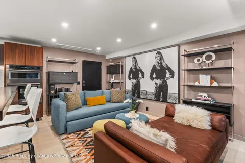 a living room with furniture kitchen view and a flat screen tv