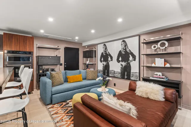 a living room with furniture kitchen view and a flat screen tv