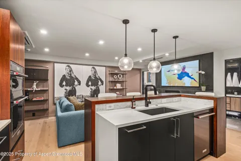 a kitchen with stainless steel appliances granite countertop a sink and a wooden floor
