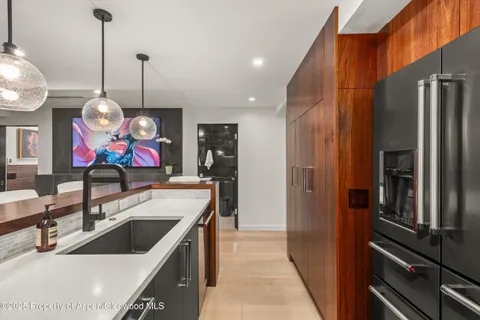 a kitchen with stainless steel appliances granite countertop a sink and a refrigerator