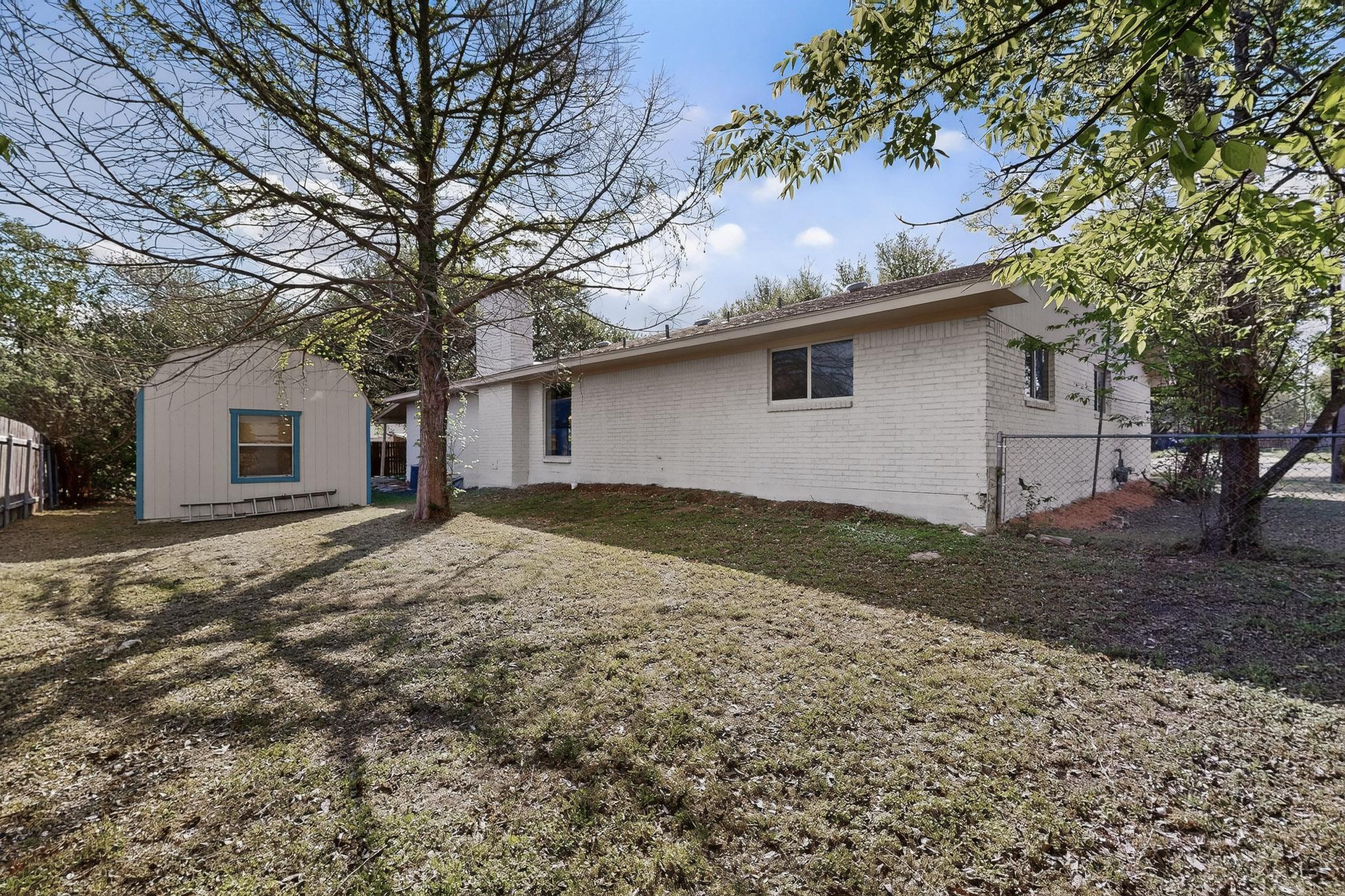 812 George Street Taylor, TX 76574 - Photo 20 of 34 View of front of home with brick siding, a chimney, and an outdoor structure