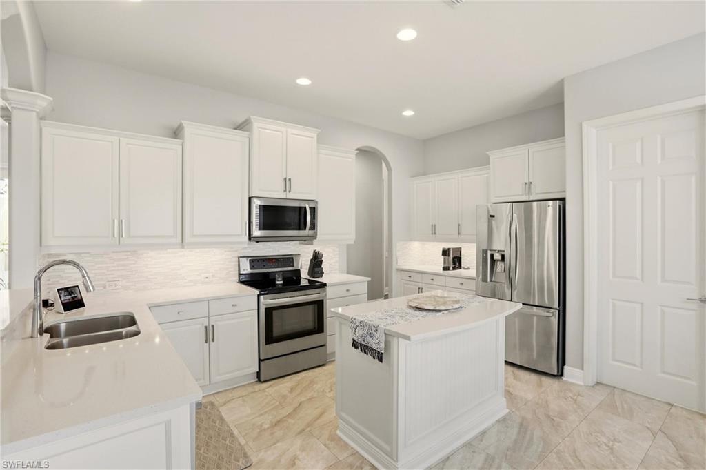 20441 Rookery Drive Estero, FL 33928 - Photo 13 of 41 a kitchen with white cabinets and stainless steel appliances