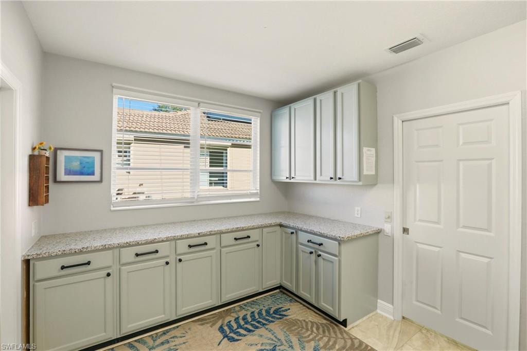 20441 Rookery Drive Estero, FL 33928 - Photo 29 of 41 a kitchen with granite countertop white cabinets and white appliances