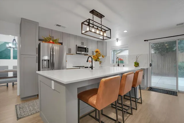 a kitchen with a table chairs refrigerator and cabinets