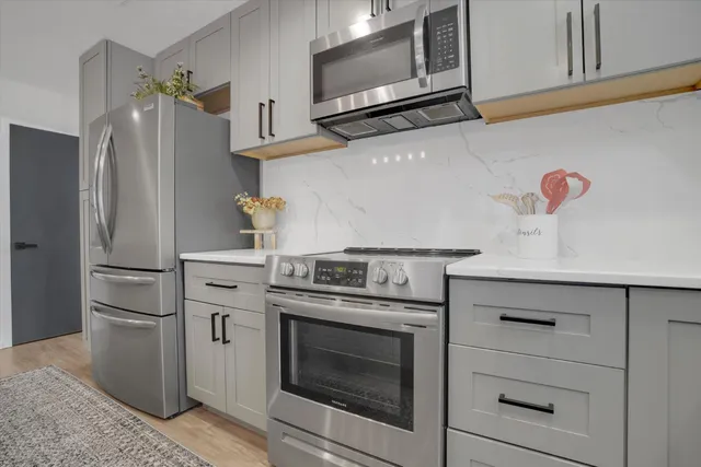 a kitchen with stainless steel appliances white cabinets and a stove top oven