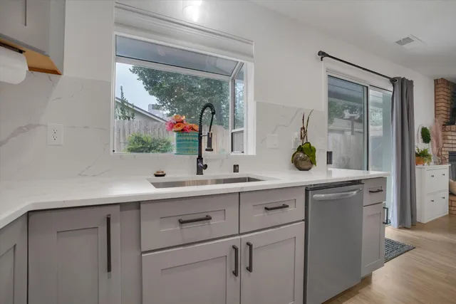 a view with double vanity sink a mirror and window