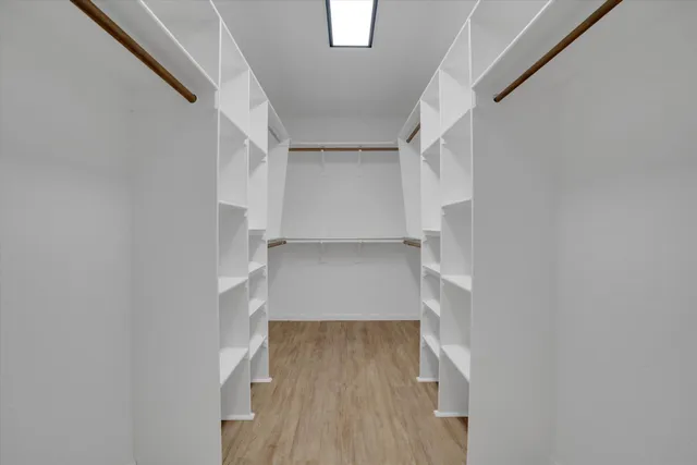 a view of walk in closet with empty racks