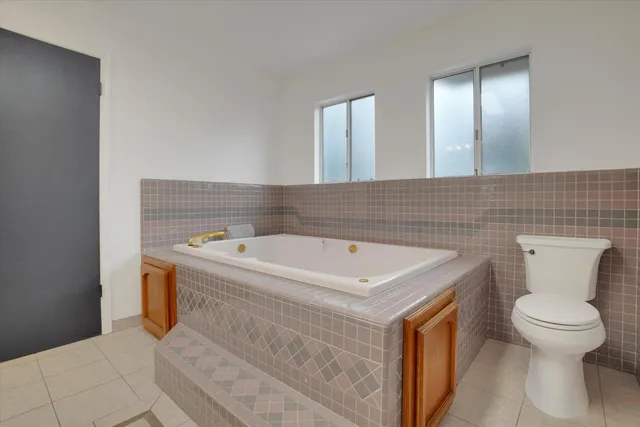 a bathroom with a tub sink and mirror