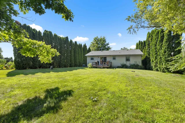 a front view of a house with yard and green space