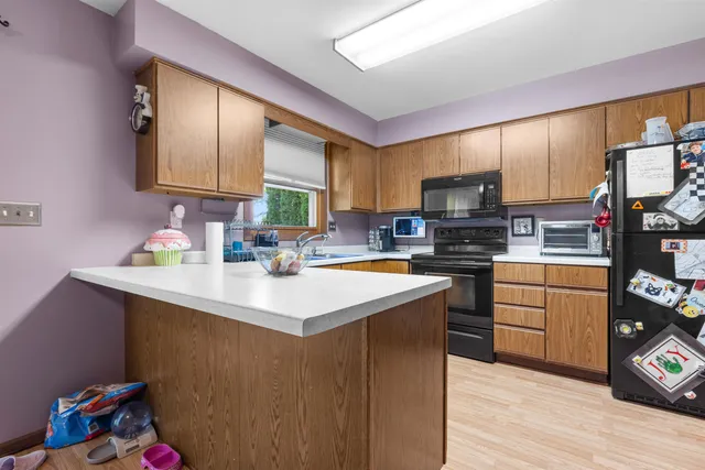 a kitchen with kitchen island granite countertop a sink cabinets and wooden floor