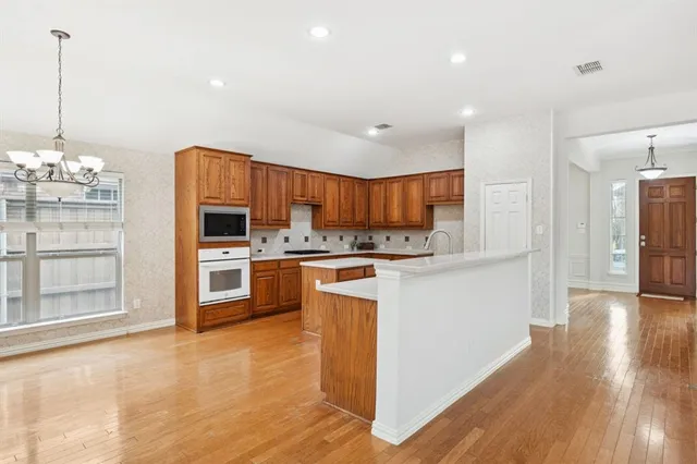 a kitchen with granite countertop white cabinets and stainless steel appliances