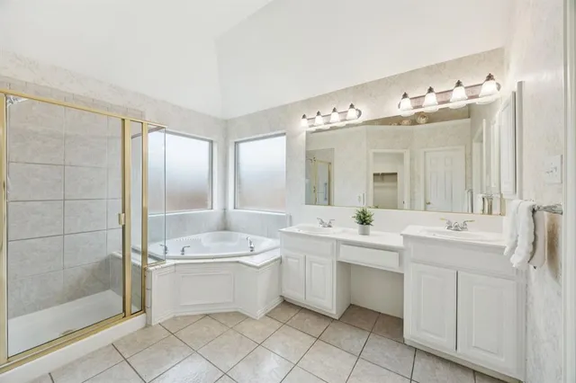 a bathroom with a double vanity sink mirror and bathtub