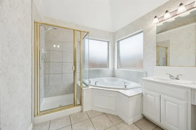 a spacious bathroom with a shower a sink and mirror