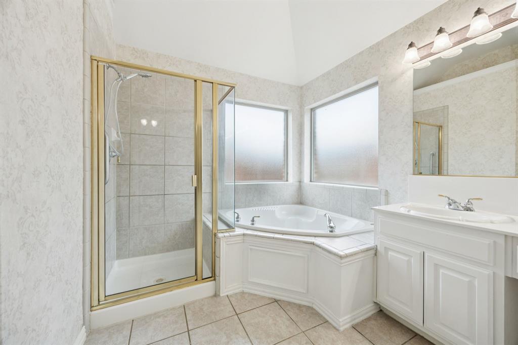 409 Fox Trail Allen, TX 75002 - Photo 20 of 31 a spacious bathroom with a shower a sink and mirror