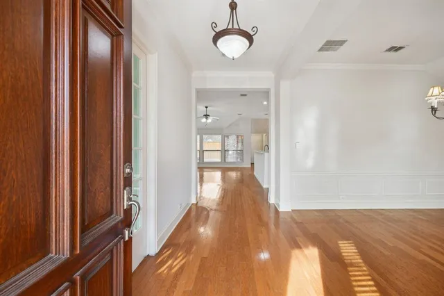 a view of a hallway with wooden floor and staircase