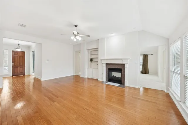 a view of an empty room with a fireplace and a window