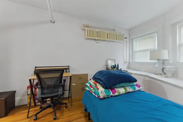 a bedroom with furniture a flat screen tv and a window