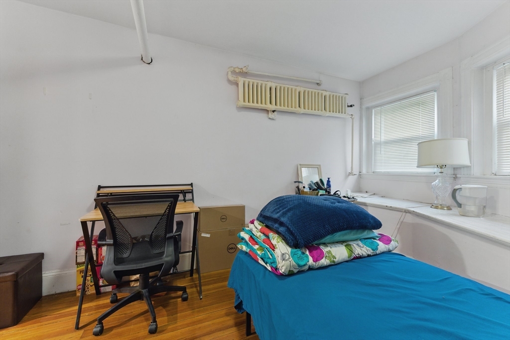 16 Garrison Road, Unit 7 Brookline, MA 02445 - Photo 16 of 33 a bedroom with a bed and wooden floor