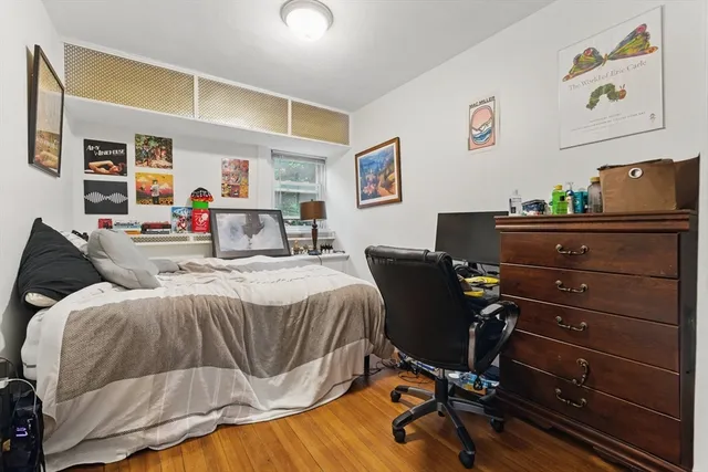 a bedroom with a bed and wooden floor