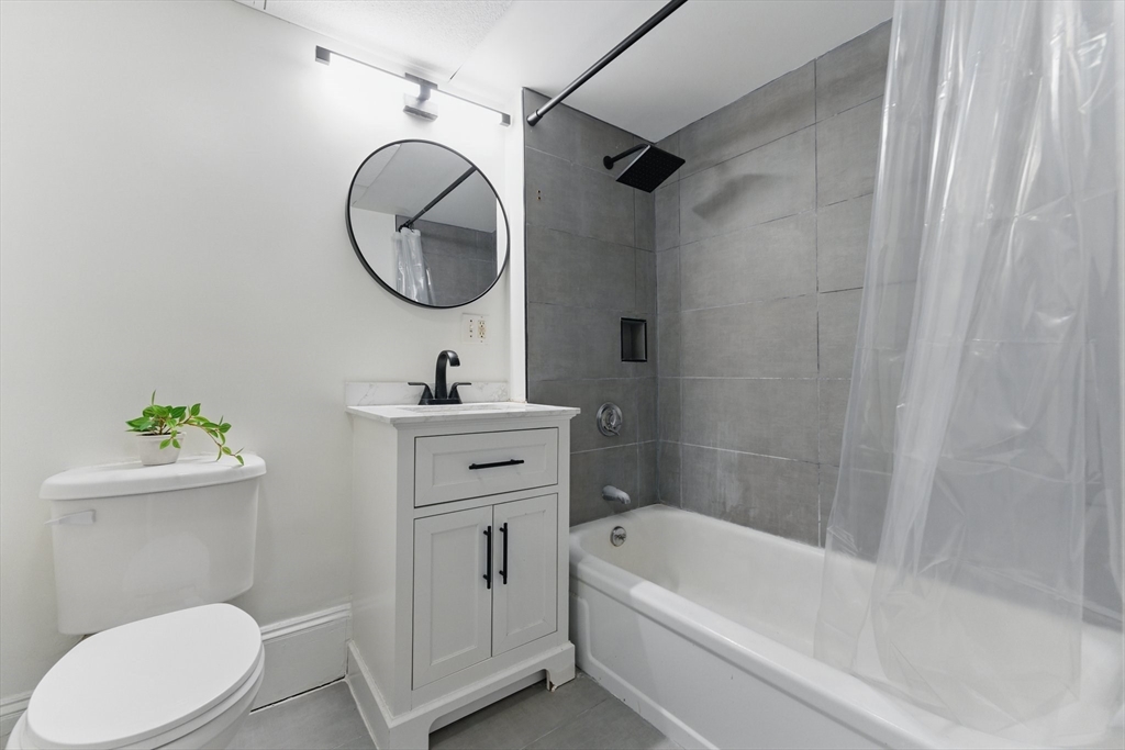 16 Garrison Road, Unit 7 Brookline, MA 02445 - Photo 24 of 33 a bathroom with a sink a mirror toilet and bathtub