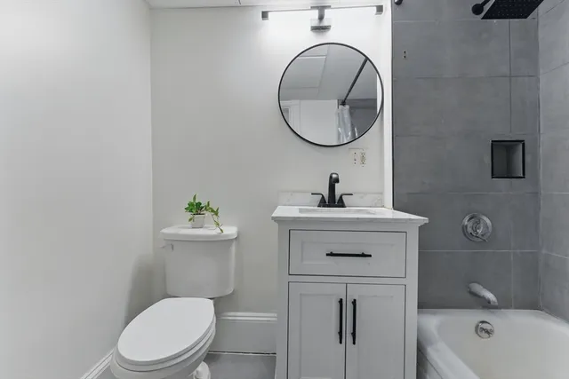 a bathroom with a sink a toilet and a mirror