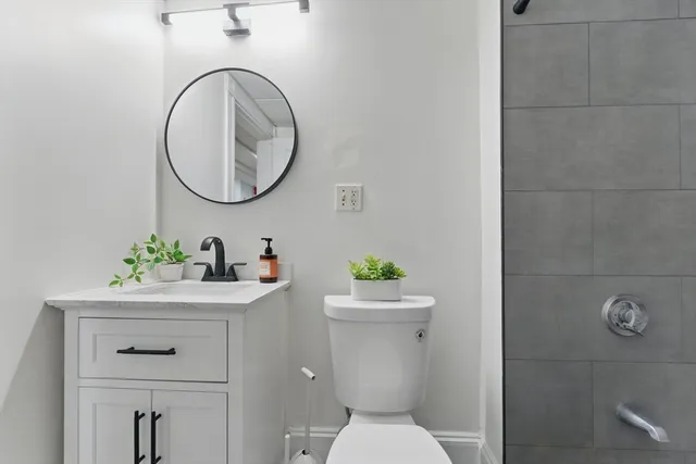 a bathroom with a toilet a sink and a mirror