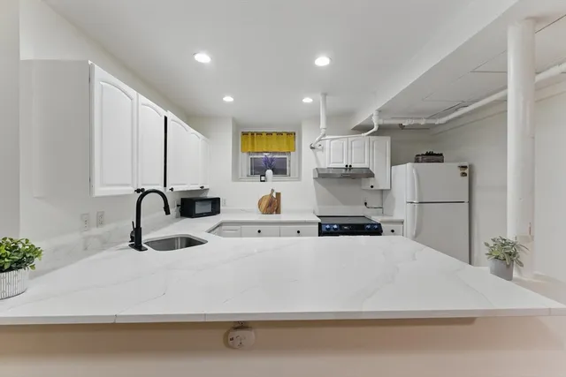 a view of kitchen with stainless steel appliances granite countertop a sink stove and refrigerator