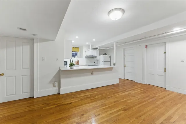 a view of kitchen with wooden floor and stainless steel appliances