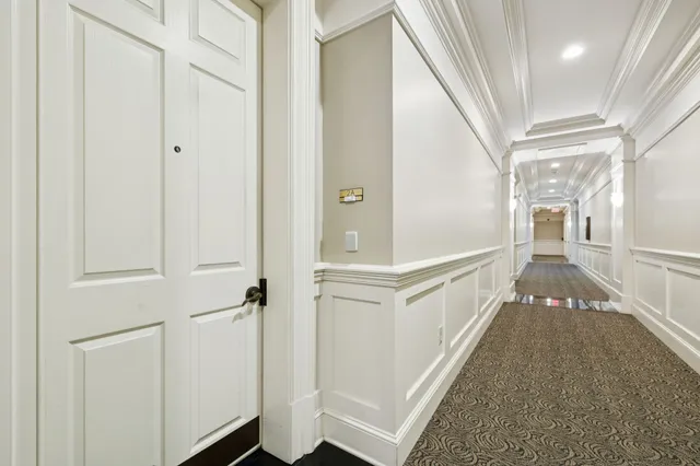 a view of a hallway with wooden floor and staircase